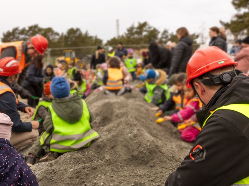 En grupp människor som sitter på en jordhög.