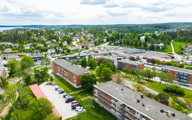 En flygbild av ett bostadsområde med bilar parkerade på tomten.