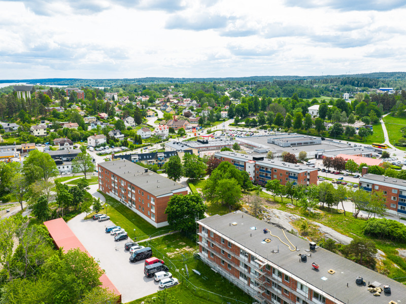 En flygbild av ett bostadsområde med bilar parkerade på tomten.