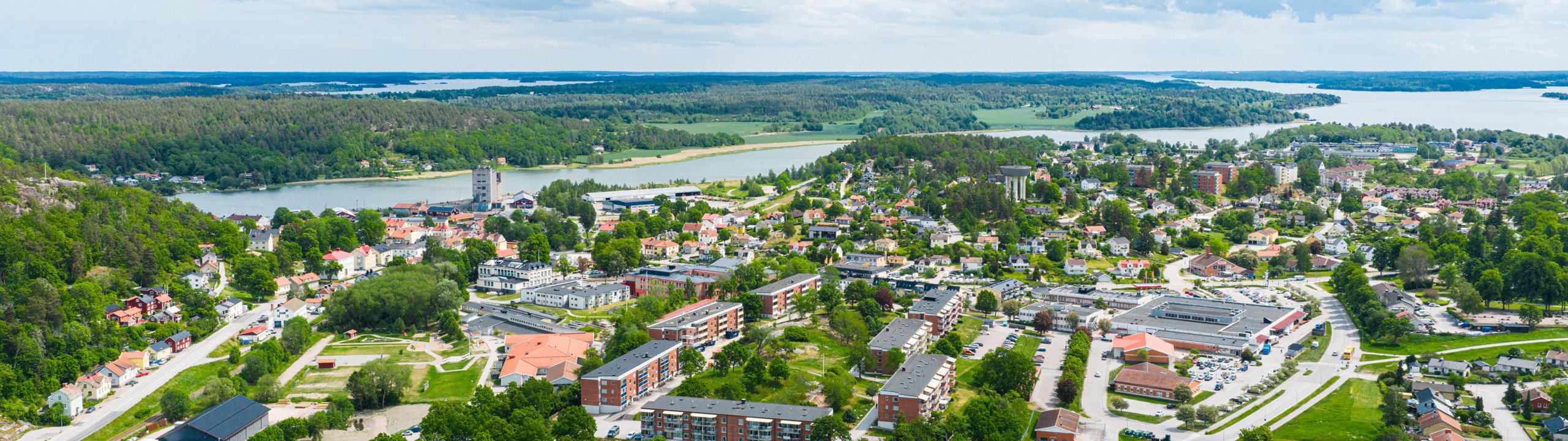 En flygbild av en liten stad med en sjö i bakgrunden.