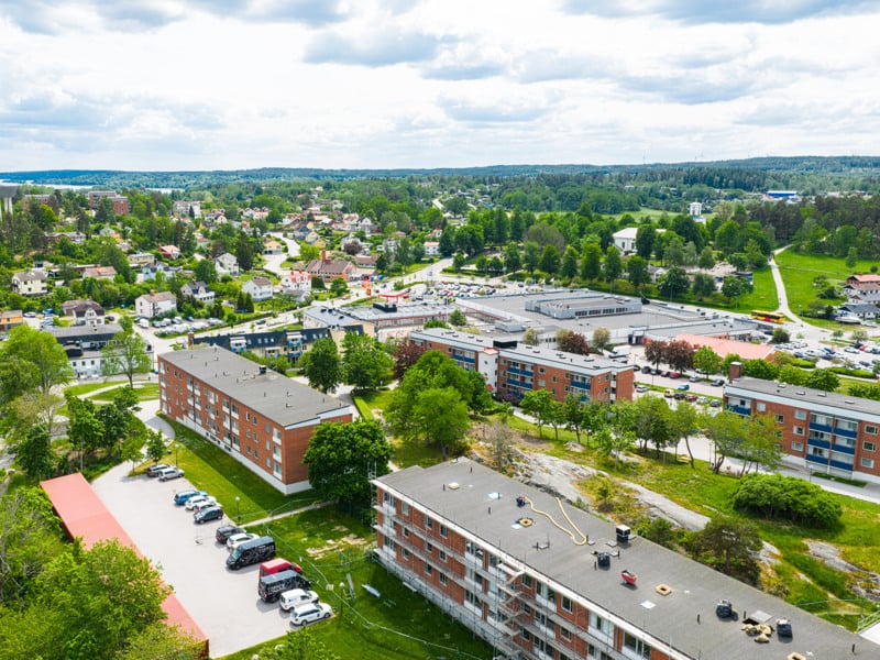 En flygbild av ett bostadsområde med bilar parkerade på tomten.