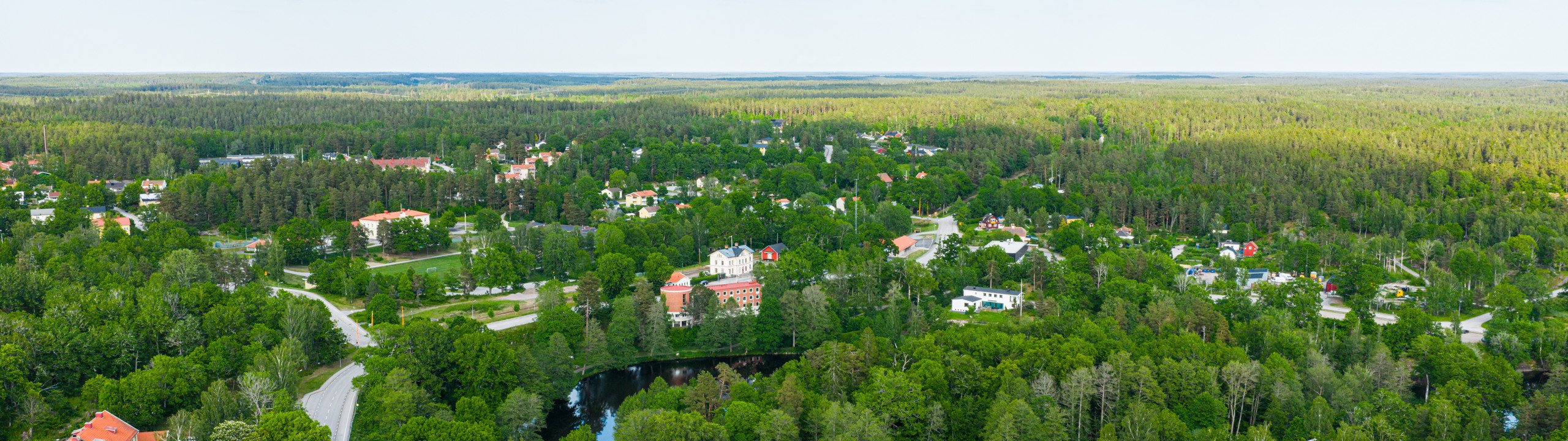 En flygbild av en liten stad omgiven av träd.