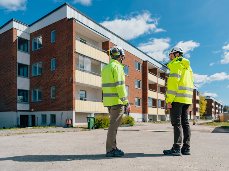 Några män som står bredvid varandra framför en byggnad.