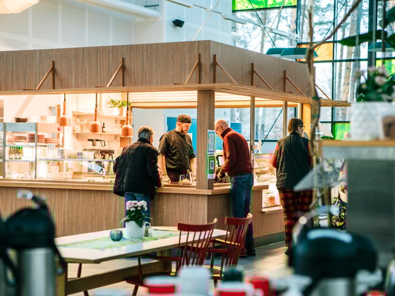 En grupp människor som står vid en disk på en restaurang.
