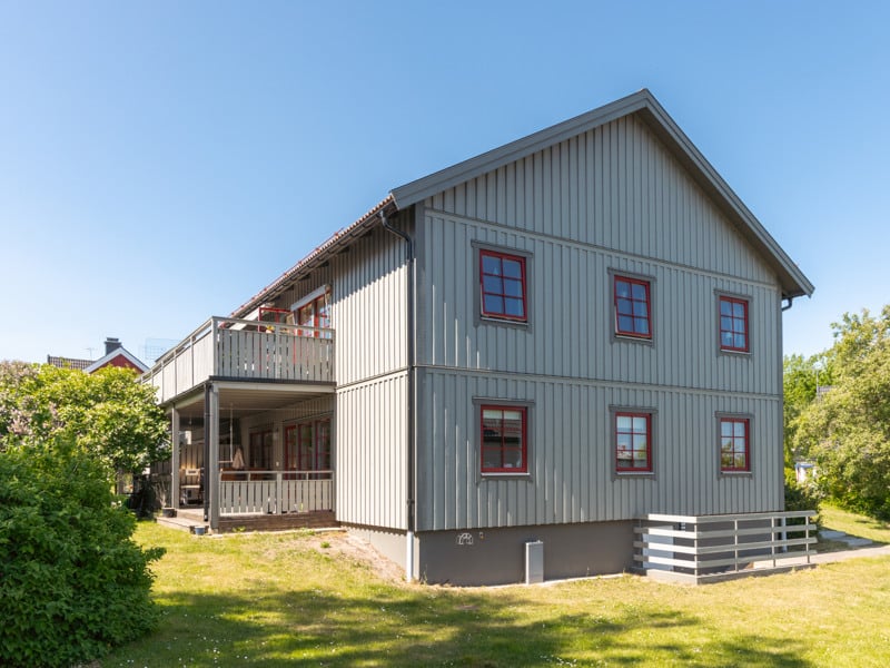 Ett tvåvåningshus med ett däck på framsidan.