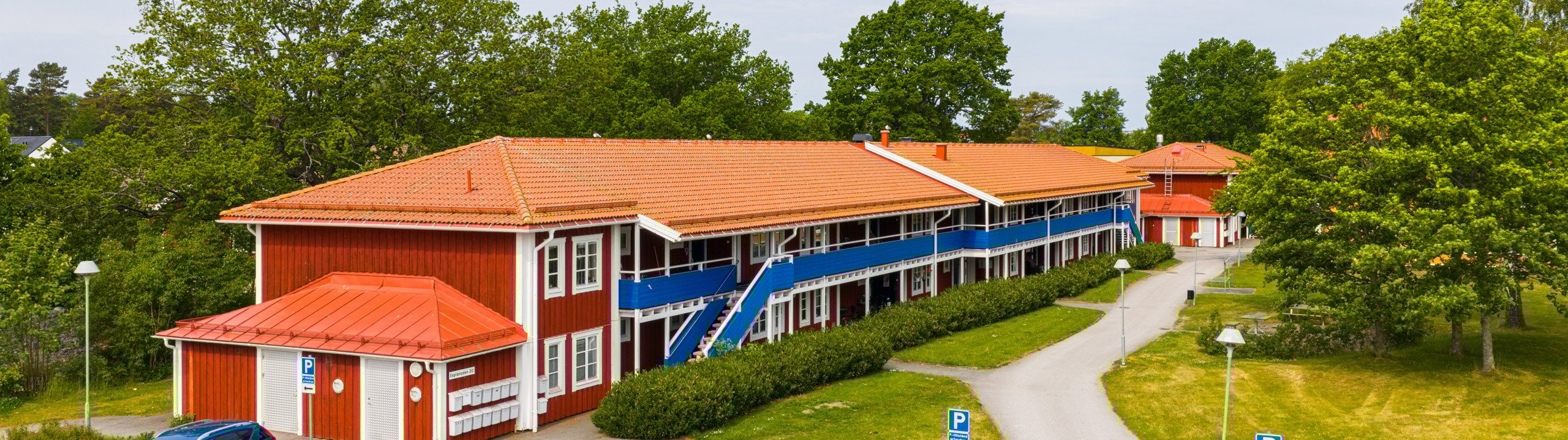 En parkeringsplats med bilar parkerade framför en byggnad.
