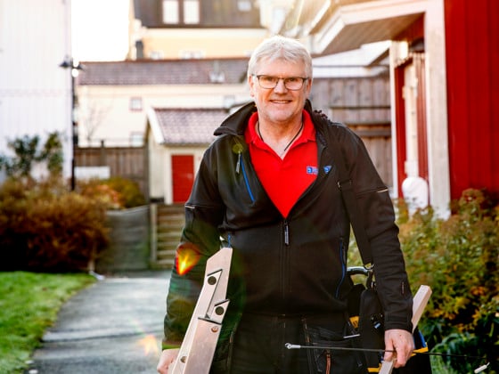 En man som håller ett par skidor i sina händer.