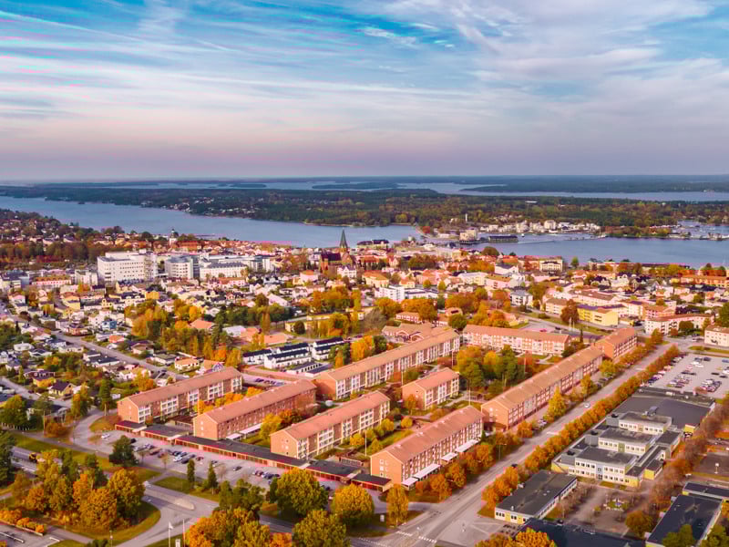 En flygbild av en stad med en sjö i bakgrunden.