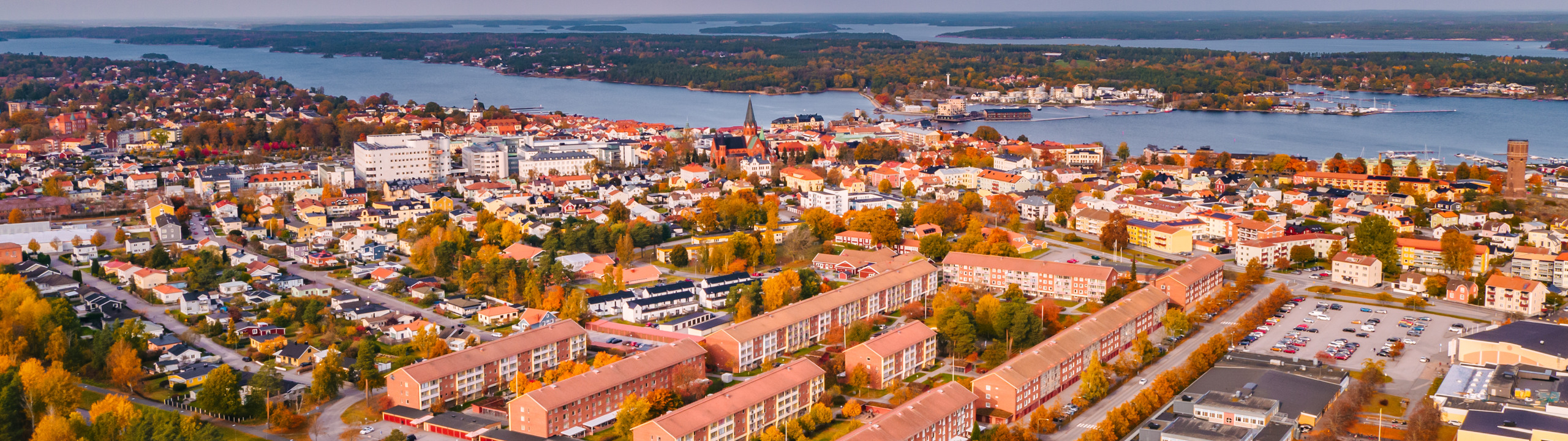 En flygbild av en stad med en sjö i bakgrunden.