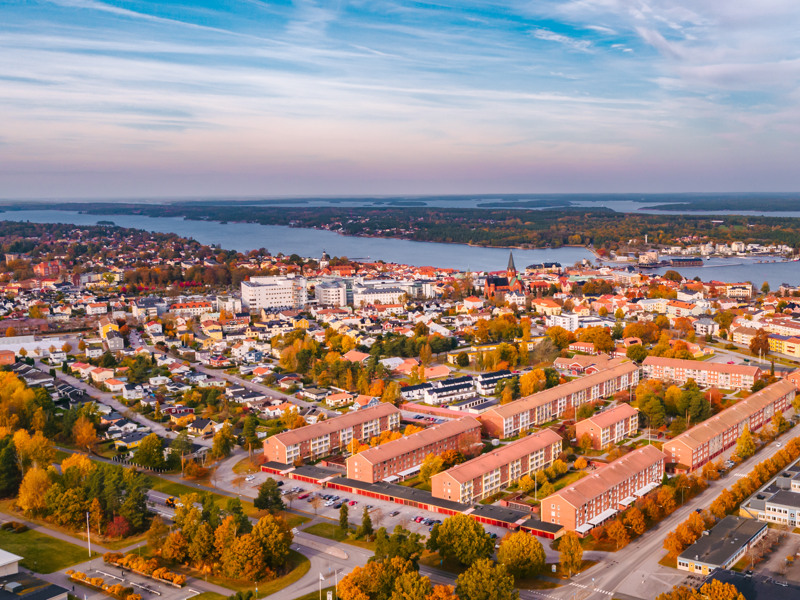 En flygbild av en stad med en sjö i bakgrunden.