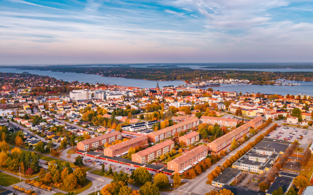En flygbild av en stad med en sjö i bakgrunden.