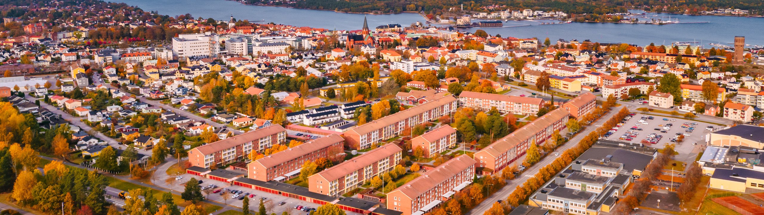 En flygbild av en stad med en sjö i bakgrunden.