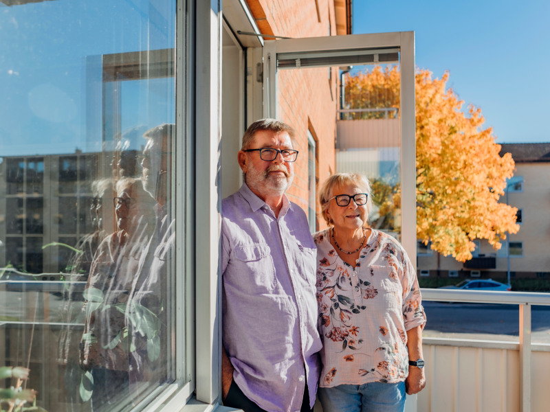 En man och en kvinna som står bredvid varandra framför ett fönster.