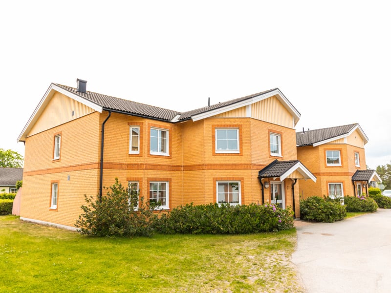 Ett gult hus med en bil parkerad framför.