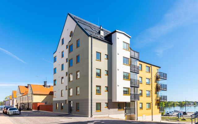 Ett hyreshus med en bil parkerad framför sig.