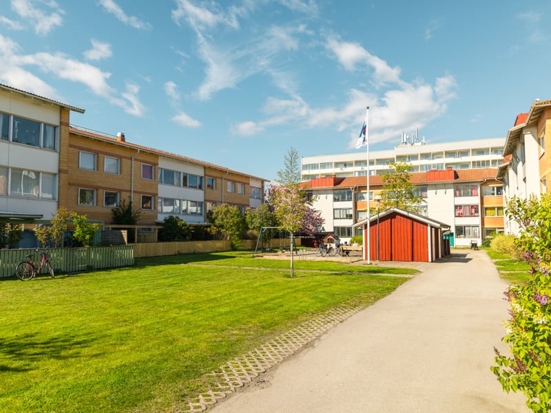 En gångväg som leder till en byggnad med en röd dörr.