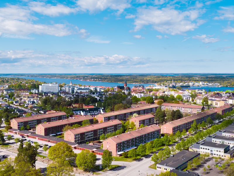En flygbild av en stad med en sjö i bakgrunden.