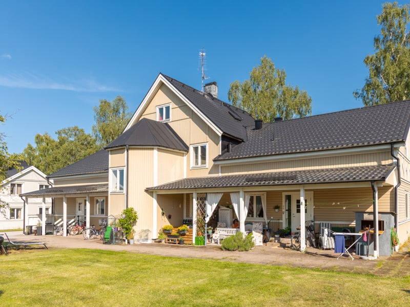 Ett hus med många fönster och mycket gräs.