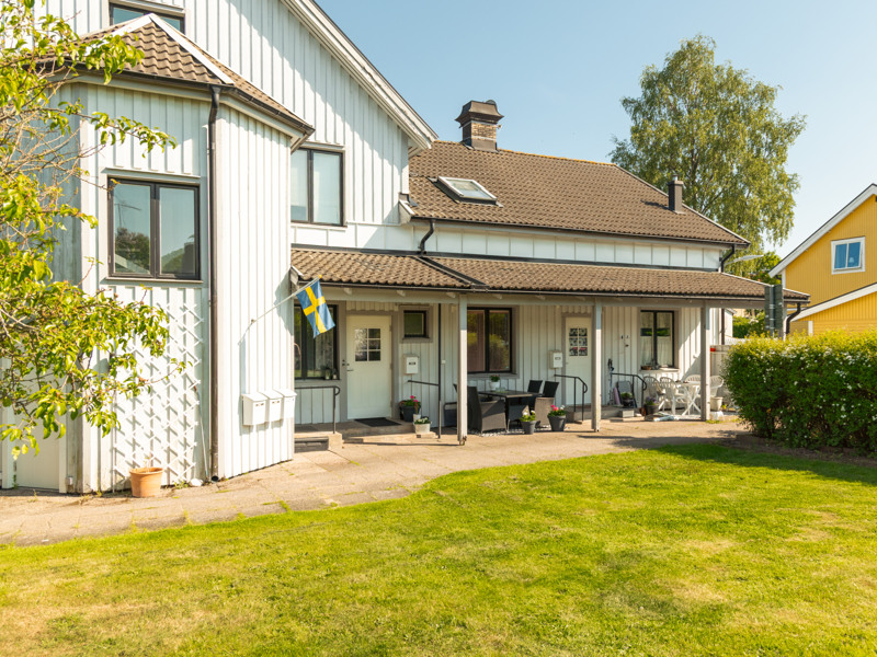 Ett vitt hus med ett gult hus bakom sig.