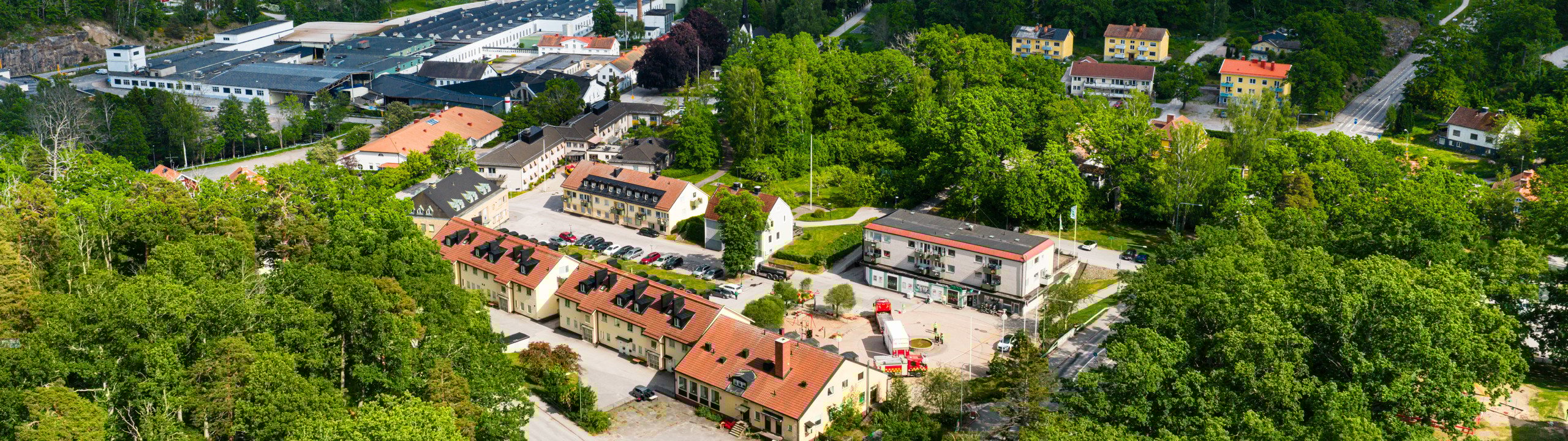 En flygbild av en stad omgiven av träd.