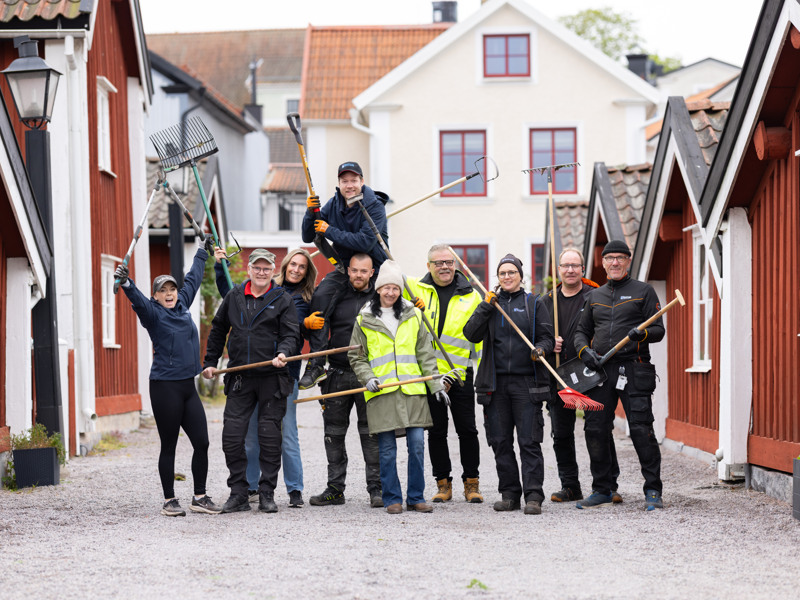 En grupp människor som står framför en rad med hus.