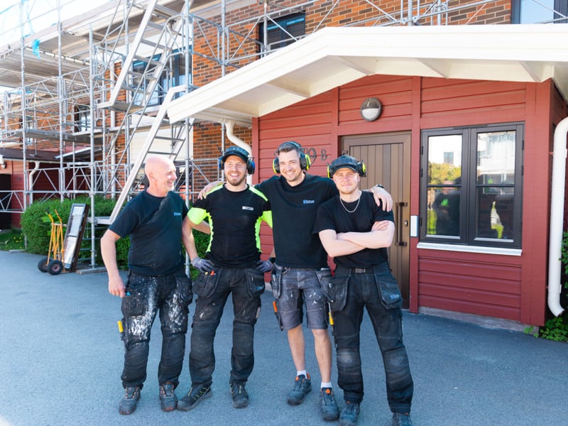 En grupp män som står bredvid varandra framför en byggnad.