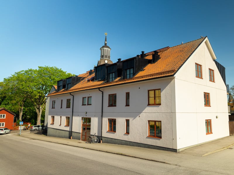 En stor vit byggnad med ett klocktorn på toppen.