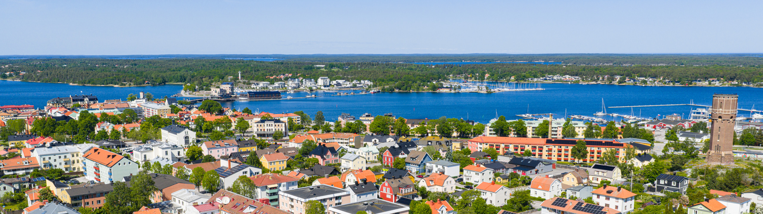 En flygbild av en stad med en sjö i bakgrunden.