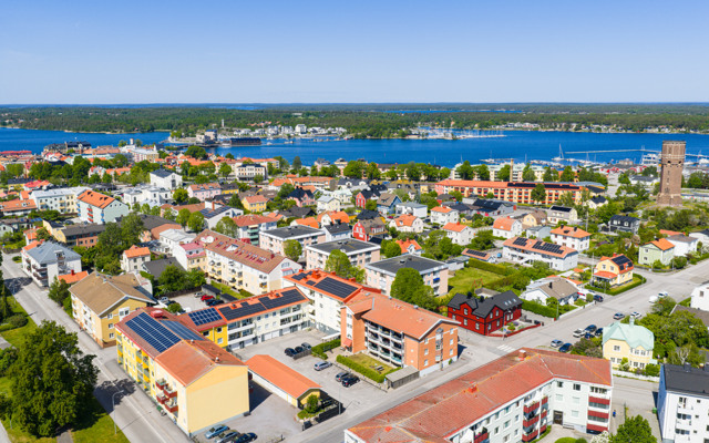 En flygbild av en stad med en sjö i bakgrunden.