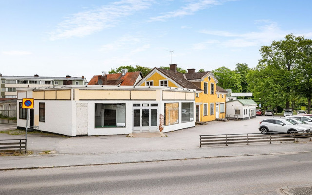 En tom parkeringsplats framför en gul byggnad.