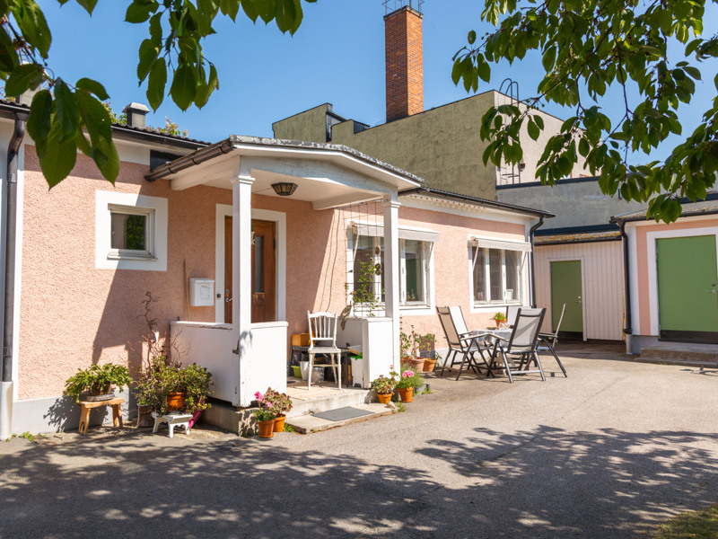 Ett litet rosa hus med en grön dörr.