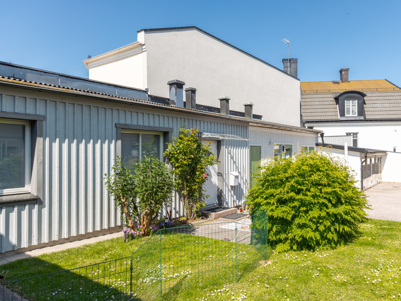 Ett vitt hus med en grön gräsmatta framför.