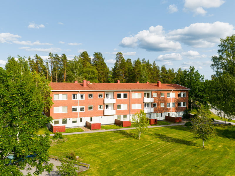 En flygbild av ett hyreshus i skogen.