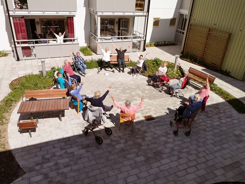 En grupp människor som sitter runt en innergård.