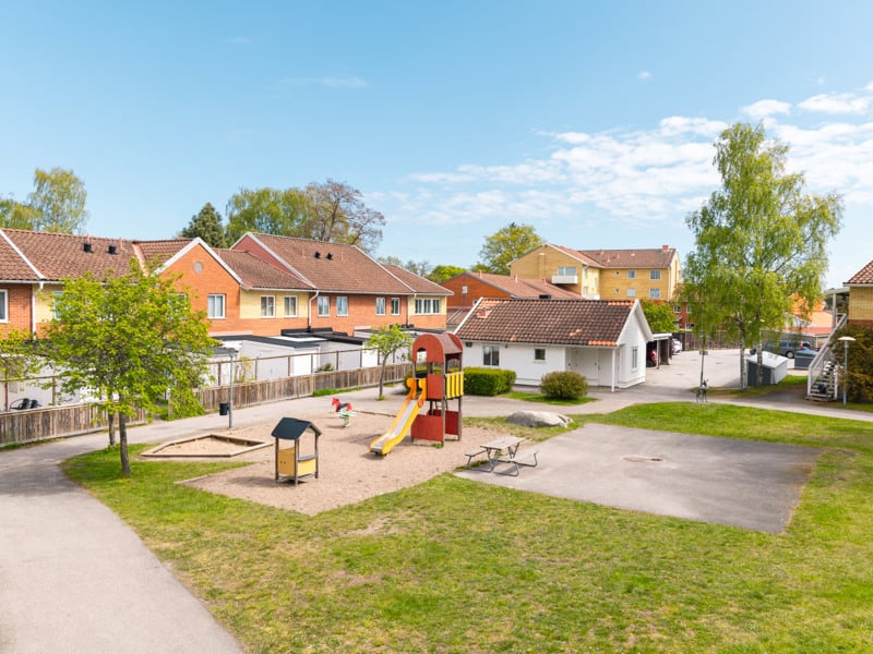En park med en lekplats och ett lekområde.