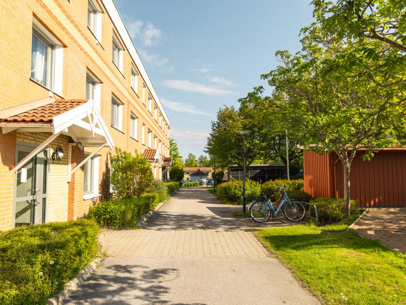 En cykel parkerad vid sidan av en väg bredvid en byggnad.