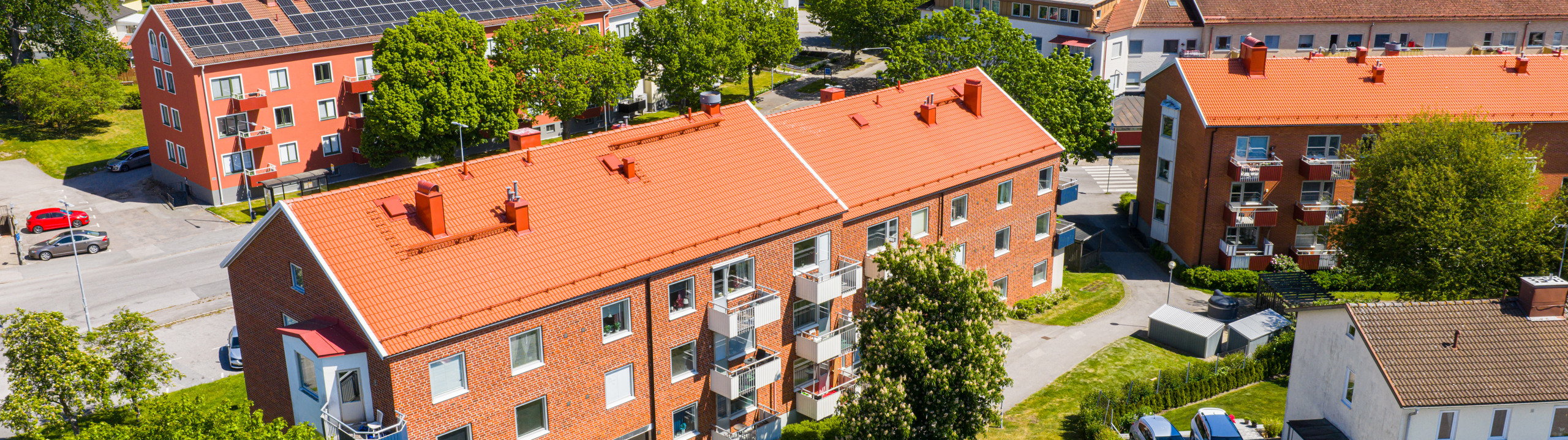 En flygbild av en röd tegelbyggnad med solpaneler på taket.