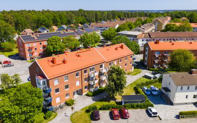 En flygbild av en röd tegelbyggnad med solpaneler på taket.
